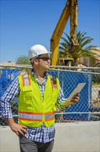 Caucasian construction worker holding digital tablet