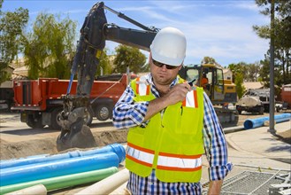 Caucasian construction worker listening to walkie-talkie