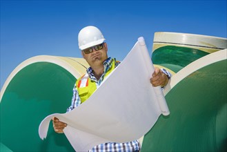 Caucasian construction worker reading blueprint