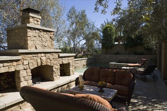 Outdoor sitting area with sofas near stone fireplace