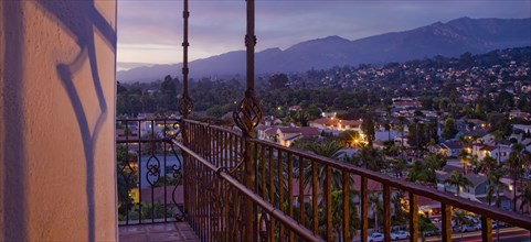 Detail wrought iron railing of balcony with sunset view of Santa Barbara