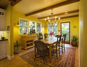 Yellow dining room with wooden ceiling beams