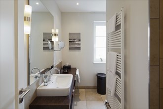 Towel warmer and sink in contemporary bathroom