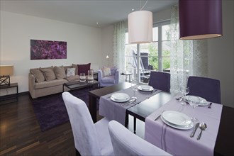 Interior of a contemporary living room with purple painting on wall