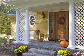 Pumpkins and flower pots at front door of single family home
