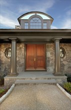 Symmetrical view of front entrance to home with dormer