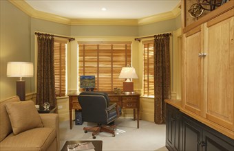 Home office with leather chair and bay window