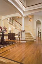 Foyer with maple hardwood floors and carpeted staircase