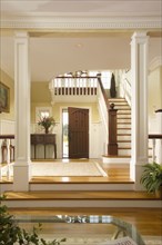 Foyer of traditional home with staircase and pillars
