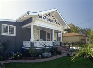 Front exterior view of a blue bungalow with white trim