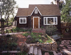 Front exterior wooden Cape Cod cottage and landscaping