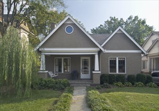 Front exterior of a one story bungalow with white trim at Nashville