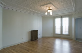 Empty room in apartment with hardwood floor and heater