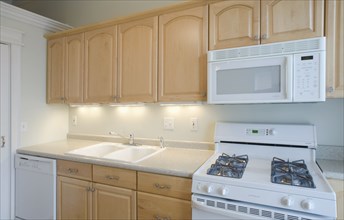 Empty kitchen with light colored cabinets
