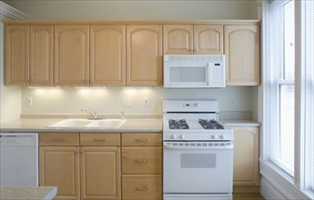Empty kitchen with light colored cabinets