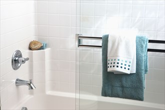 Towels on sliding glass shower door in bathroom