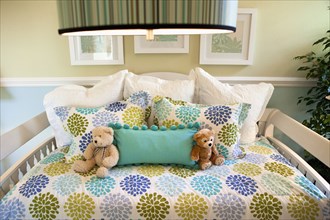 Teddy bears and pillows arranged on day bed