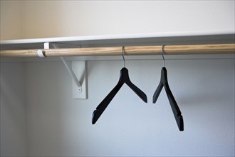 Coat hangers hanging in empty white closet