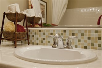 Close-up of tiled counter and washbasin in the bathroom at home