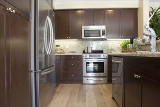 Kitchen with brown cabinets and stainless steel refrigerator at home
