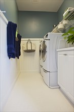 Washing machines with towels hanging on wall in the laundry room