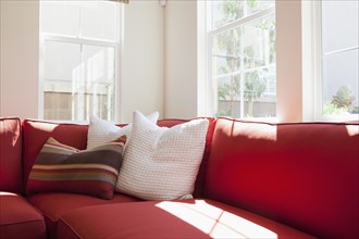 Cropped red couch with cushions in the living room at home