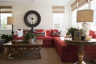 Contemporary living room with red sectional sofa and large wall clock at home