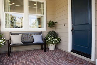 Brick flooring porch with closed door and bench
