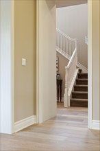 Hallway leading to stairs with banister at home