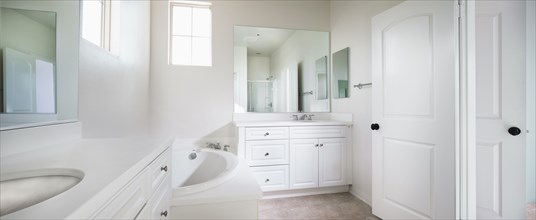 View of a contemporary white bathroom with bath
