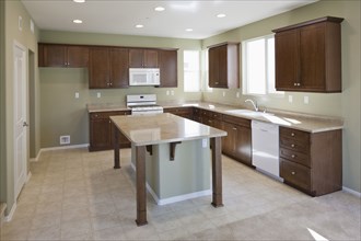 Kitchen having brown cabinets and island at home