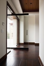 Hallway with wooden floor and open glass door