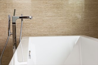 Contemporary bathroom with tap at cropped bathtub