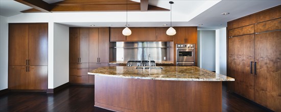 Kitchen having brown cabinets and island at home