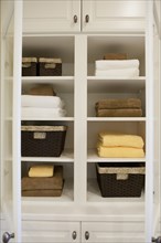 View of folded towels and baskets in shelf at home