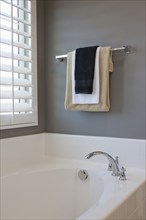 Towel rail and bathtub by window in domestic bathroom