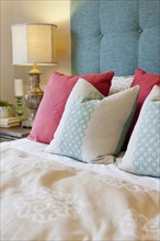 Patterned pillows arranged on bed in bedroom