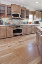 Hardwood floor and wooden cabinets in kitchen
