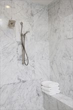 Shower head on marble bathroom wall at home