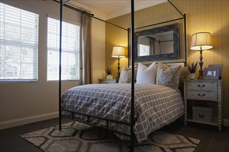 Four post bed with lit table lamps in contemporary bedroom