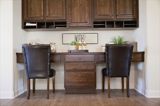 Chairs at study table with brown cabinets at home