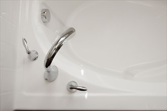 Close-up shot of faucet at cropped bathtub in the bathroom