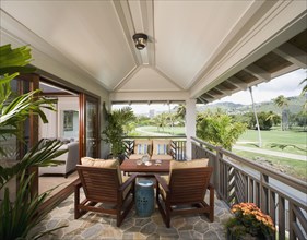 Back patio with wood furniture and view of golf course