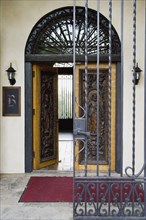 Wrought iron gate and hand carved wooden door