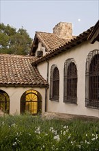 Row of windows with wrought iron grills on side of spanish style home