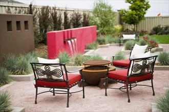 Wrought iron chairs surrounding fire pit in back yard