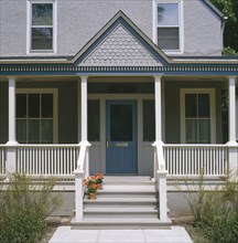 Front porch of gray stucco house with dark blue trim
