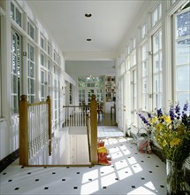 Hallway with windows and gardening equipment by staircase