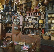 Interior of a country kitchen with old utensils hanging from ceiling
