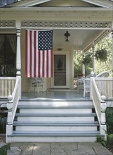 American flag hanging at front porch of house